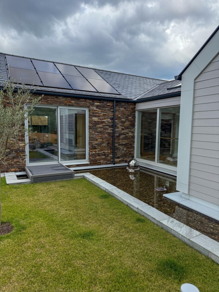 Exterior of a modern home with solar panels and a courtyard garden