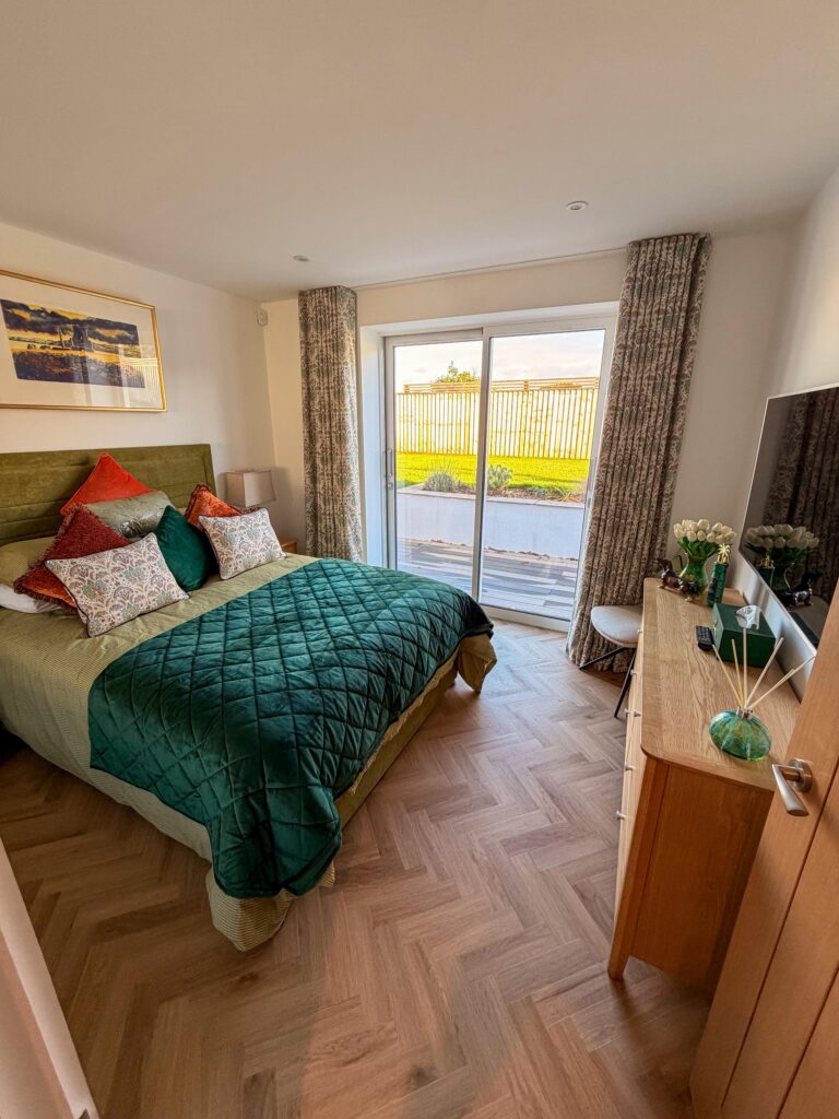 Bedroom with herringbone flooring and patio doors