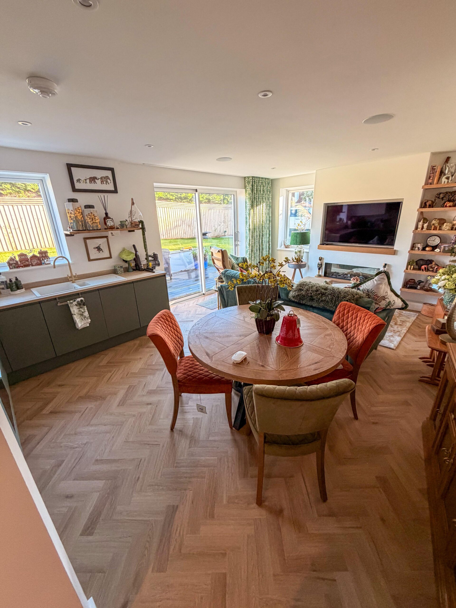 Open-plan dining and living area with a wall-mounted TV