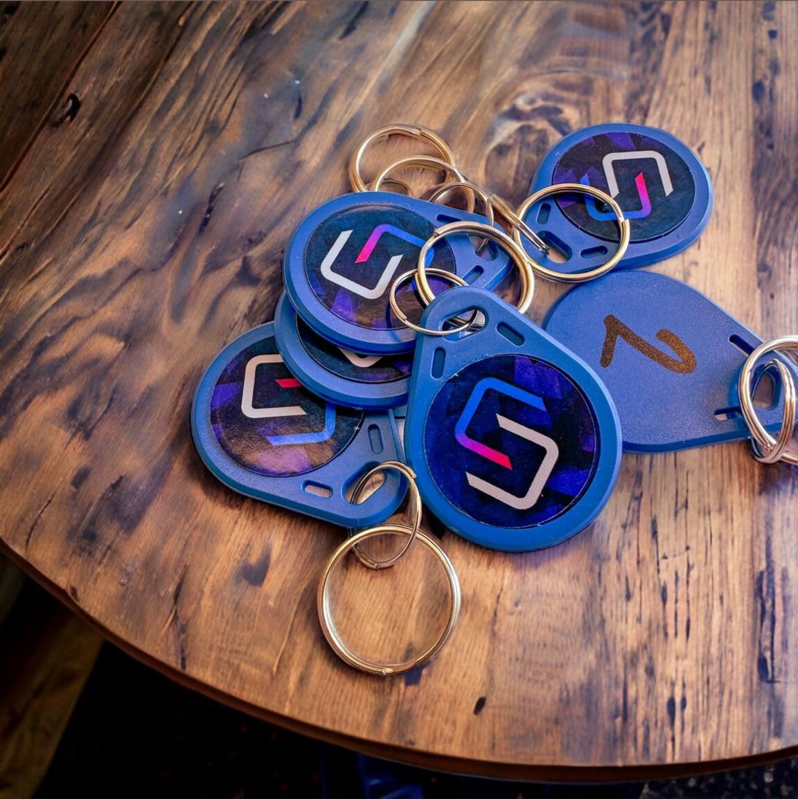 Branded access control key fobs on a wooden table